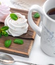 Handmade cream and strawberry marshmallows. Adorned with mint leaves. Tea in a white cup with a blue ornament. On a wooden Royalty Free Stock Photo