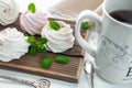 Handmade cream and strawberry marshmallows. Adorned with mint leaves. Tea in a white cup with a blue ornament. On a wooden Royalty Free Stock Photo