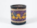 Handmade Crochet Container with Floral Pattern in Purple Yellow and Beige on White Background Royalty Free Stock Photo