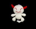 handmade crochet white devil with red ear doll on black background Royalty Free Stock Photo