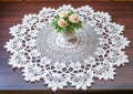 Handmade crochet white lace napkin on table with flowers in living room
