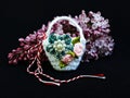 Handmade crocheted basket with spring flowers and red and white string, known as Martisor. Royalty Free Stock Photo