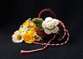 Handmade crocheted basket with spring flowers and red and white string, known as Martisor. Royalty Free Stock Photo