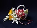 Handmade crocheted basket with spring flowers and red and white string, known as Martisor. Royalty Free Stock Photo