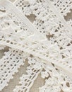 Handmade crocheted cotton organic lace ribbons on linen background. White original organic crochet frame, Knitted pattern backdrop