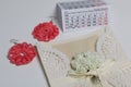 Handmade crocheted earrings. Greeting card. Nearby is a fragment of the calendar with the month of December. On white background