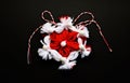 Handmade crocheted flower with red and white string, known as Martisor.