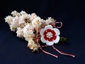 Handmade crocheted flower with red and white string, known as Martisor.