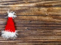 Handmade crocheted Santa hat on wooden table with copy space, top view flat lay