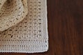Handmade crocheted with white cotton threads on a wooden table