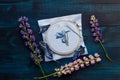 Handmade cross-stitch with floral pattern on canvas on wooden background