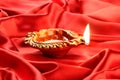 Handmade Diwali Clay Lamp on Red Satin Background