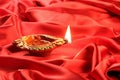 Handmade Diwali Clay Lamp on Red Satin Background