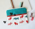 Double pocket pouch with dogs, clips, pencils, notebook and washi tape over white