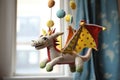 a handmade dragon toy hanging from a baby mobile