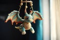 a handmade dragon toy hanging from a baby mobile