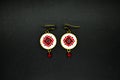 Handmade earrings with red and black romanian traditional model. Isolated on black.