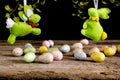 Handmade easter rabbits and eggs on wooden table. Black background.