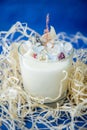 Handmade ecofriendly candle on a blue background. Soya wax healthy candle with dried flowers. Scented candles with wick. Flavored