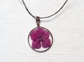 Handmade epoxy resin jewelry. pendant, hydrangea in copper frame. dried flowers. herbarium, oshibana. on white