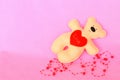 Handmade felt bear. Beige felt bear on pink background, hand-stitched toy, a craft out of felt