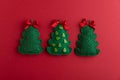 Handmade Felt Christmas Tree Ornaments with Bows on Red Background Royalty Free Stock Photo