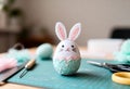 Handmade felt Easter bunny egg on a crafting table. DIY wool needle felting project with tools and supplies in the background Royalty Free Stock Photo