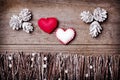 Handmade from felt hearts on wooden background. Craft arranged from sticks, twigs, driftwood and pine cones white and shiny.