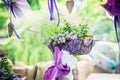 Handmade flowerbed with beautiful colored flowers inside, standing on the lawn in the park on background of blurred natural land Royalty Free Stock Photo