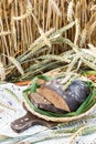 Handmade fresh rye bread on a wicker tray and laces in crop field background Royalty Free Stock Photo