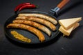 Handmade fried thin sausages, mustard, chili, and hard cheese