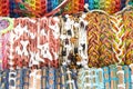 Handmade friendship bracelets in various colors and patterns lined up in rows