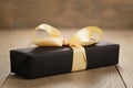 Handmade gift black paper box with yellow ribbon bow on wood table Royalty Free Stock Photo