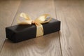 Handmade gift black paper box with yellow ribbon bow on wood table Royalty Free Stock Photo