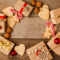 Handmade gift boxes, candy canes, walnut and gingerbread cookies on rustic wooden background, top view, copy space, frame. Royalty Free Stock Photo