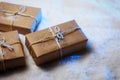 Handmade gift boxes from craft paper over snowy wooden table in blue light. Royalty Free Stock Photo