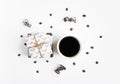 Handmade gifts and a cup on white background decorated with coffee beans and paper serpentine. Top view, flat lay