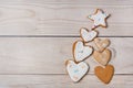 Handmade gingerbread cookies with white icing in the shape of hearts are laid out on a white wooden background. Flat lay Royalty Free Stock Photo