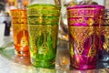 Handmade glass cups with bright colours and golden ornaments on display at street souvenir market in Morocco