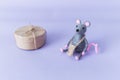 A handmade gray toy mouse with a christmas gift on a purple background. Year of the rat, chinese new year and horoscope concept. Royalty Free Stock Photo