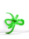 Handmade green rope node tied on white paper scroll isolated Royalty Free Stock Photo