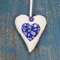 Handmade heart shape against blue wooden surface.