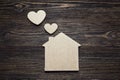 Handmade home symbol with hearts shape on wooden background with