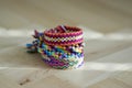 Handmade homemade colorful natural woven bracelets of friendship isolated on light blue background, pile of colorful handcrafts