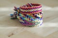 Handmade homemade colorful natural woven bracelets of friendship on light blue background, pile of colorful handcrafts