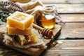 Handmade honey soap bars on honeycomb with a jar and fresh lavender flowers on a rustic wooden table background, organic Royalty Free Stock Photo