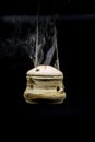 handmade incense bowl hanging with smoke isolated on black background