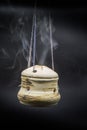 handmade incense bowl hanging with smoke isolated on black background