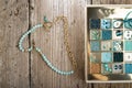 Handmade jewelry necklace  and different azure beads and chrystals in box around old style wooden background. close up Royalty Free Stock Photo