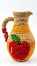 Handmade Knitted Pitcher with Apple Applique in Red Yellow and Beige on a White Background Royalty Free Stock Photo